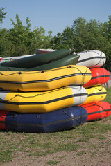 Multi-colored rafting boats stacked on top of each other.