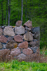 leftovers of stone block building in summer green meadow