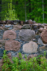 leftovers of stone block building in summer green meadow