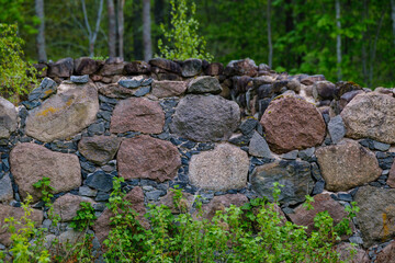 Fototapeta na wymiar leftovers of stone block building in summer green meadow