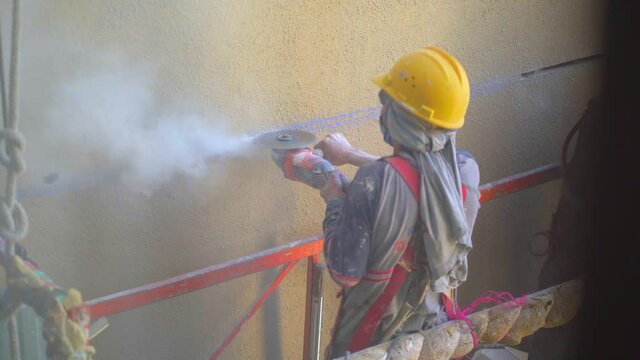 Worker using circular saw. Worker with helmet in contruction