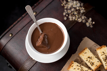 Chocolate caliente en taza blanca con bizcocho en una vieja maleta marrón. Desayuno Español