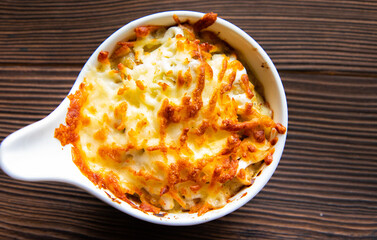 French cuisine is julienne. with mushrooms, in white form close-up