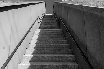Long concrete steps upstairs. Gray cement staircase to the hill