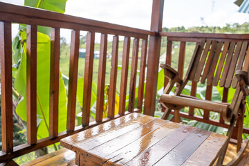 Wooden furniture in a terrace of a hotel with the views of the jungle