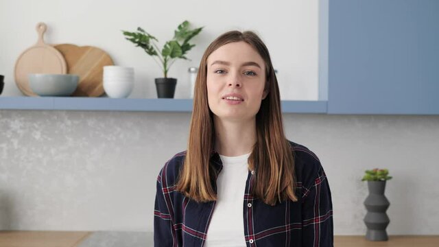 Portrait of young beautiful woman video blogger vlogger influencer sitting at home background speaking looking at camera webcam recording lifestyle cooking blog vlog holding online course videochat.