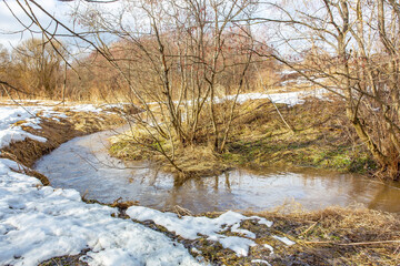 a stormy stream flows on a sunny spring day