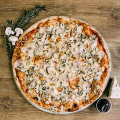 Large pizza with ham and porcini mushrooms. Pizza ingredients. pizza with rosemary sprigs and sauce