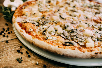 Large pizza with ham and porcini mushrooms. Pizza ingredients. pizza with rosemary sprigs and sauce