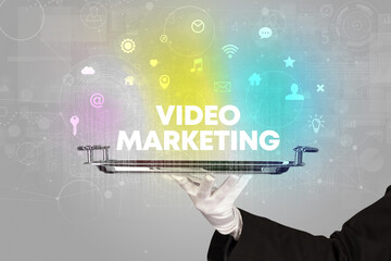 Waiter serving social networking with VIDEO MARKETING inscription, new media concept