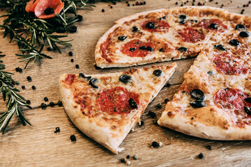 Pepperoni pizza with olives cut into pieces. Pizza without one slice