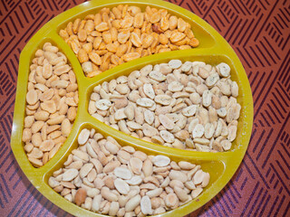peanuts are salted in spices with different flavors on the table in a bowl. beer snack