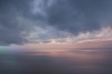 evocative image of clouds seen from an airplane with the sea in the background
