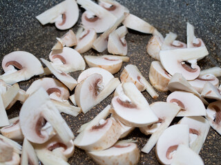 sliced raw mushrooms in a frying pan. cooking dinner.