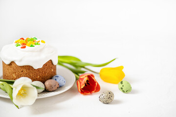 Easter composition with traditional Easter cake, painted quail eggs and tulips. Selective Focus