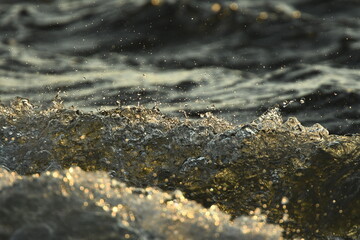 water drops and waves splash in sunset light
