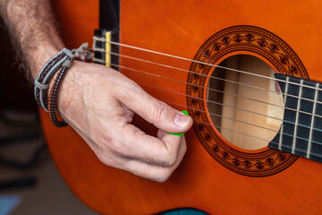 Fototapeta premium Man playing classical guitar with a plectrum Conceptual of music, hobby