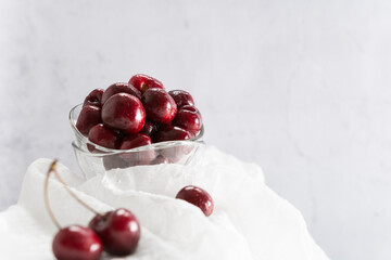Cerezas en un recipiente de vidrio sobre fondo blanco