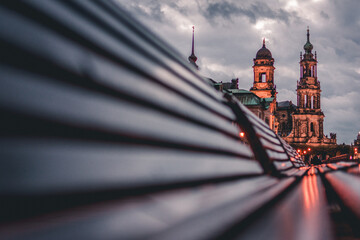 Dresden during blue hour, reflection of sighs on benches at waterfront, Germany