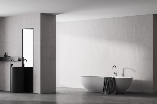 Modern bathroom interior with white bathtub and marble sink with rectangle vertical mirror, in eco minimalist style with concrete floor and walls. No people. 3D Rendering