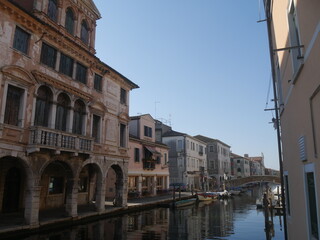 Fototapeta na wymiar Chioggia, Vena Canal with colorful ancient buildings on both sides and Grassi Palace