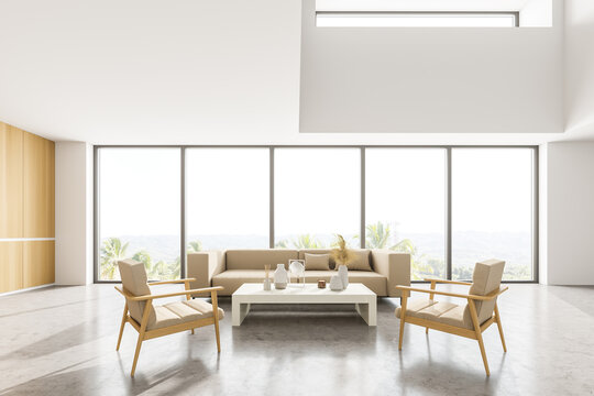 Light living room with sofa and armchairs near panoramic windows