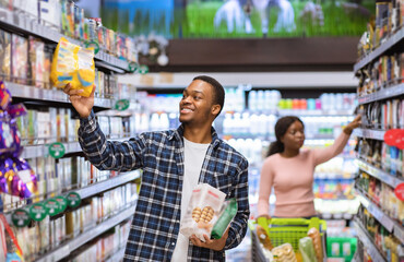 Grocery shopping. African American couple buying products at supermarket, copy space