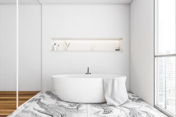 White bathtub with towel near window