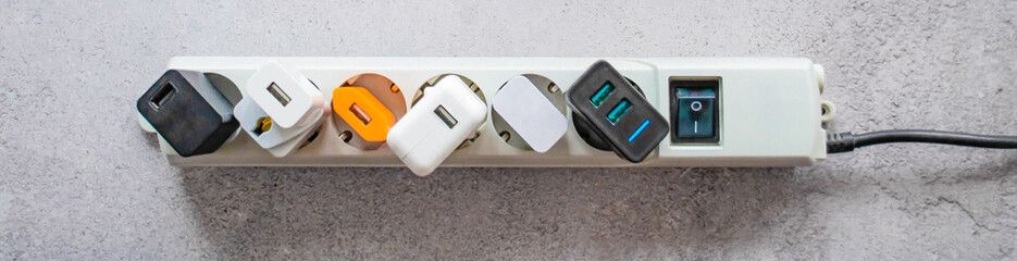 Banner running modern extension power strip with many different USB DC output ports. Cracked concrete background. Copy space