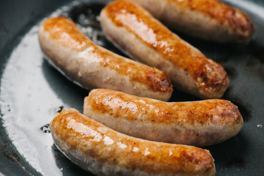 Closeup of Italian sausage links frying in a pan