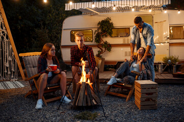 Friends warming themselves by the bonfire, camping