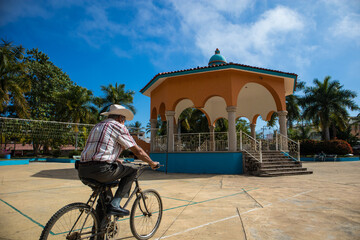 A man rides his bike in front of the kiosk in the town square in Lo de Marcos, Mexico.