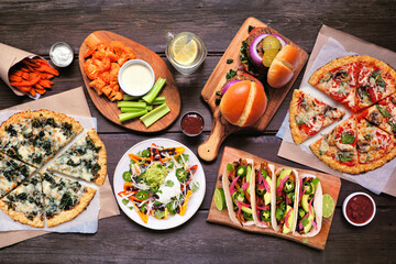 Healthy plant based fast food table scene. Top down view on a wood background. Cauliflower crust...