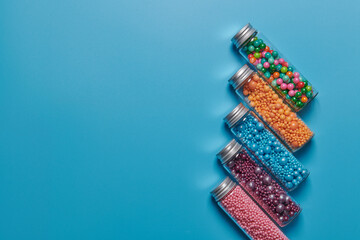 colored candies in jars on a blue background