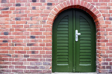 red brick wall and a green door