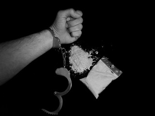 Handcuffed man and cocaine drug powder pile and bag, arrested drug dealer