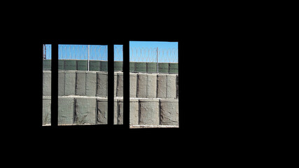 view of window that big hesco and perimeter wall