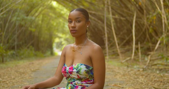 A young pretty girl sits in a scenic bamboo cathedral located on the Caribbean island of Trinidad
