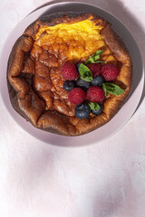 Homemade cheesecake with blueberries, currants, strawberries and mint leaves from above. Flat lay