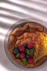 Homemade cheesecake with blueberries, currants, strawberries and mint leaves from above. Flat lay