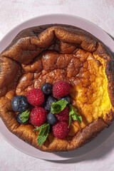 Homemade cheesecake with blueberries, currants, strawberries and mint leaves from above. Flat lay