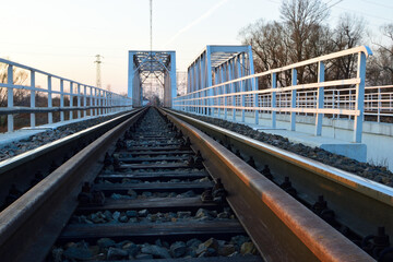 railroad tracks with a bridge in the background
