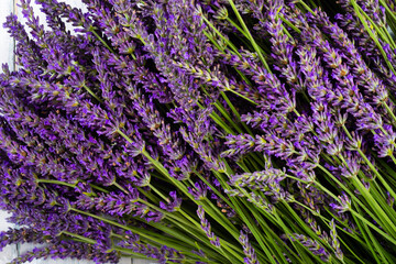 Obraz premium purple lavender flowers heap on faded white wooden table background, directly above