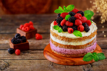 Delicious berry cake decorated with fresh raspberries and blackberries.