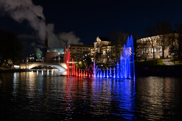 Red and blue light show in a fountain in city centre