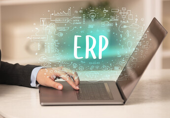 hand working on new modern computer with ERP abbreviation, modern technology concept