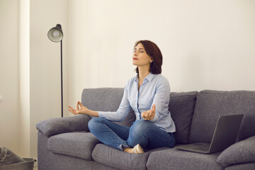 Caucasian middle age self-employed woman entrepreneur meditating on home sofa