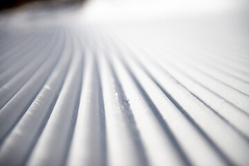 Lines in groomed snow on nordic or alpine ski terrain
