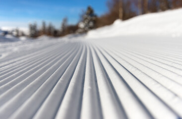 Lines in groomed snow on nordic or alpine ski terrain