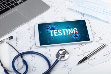 Tablet pc and doctor tools on white surface with TESTING inscription, pandemic concept